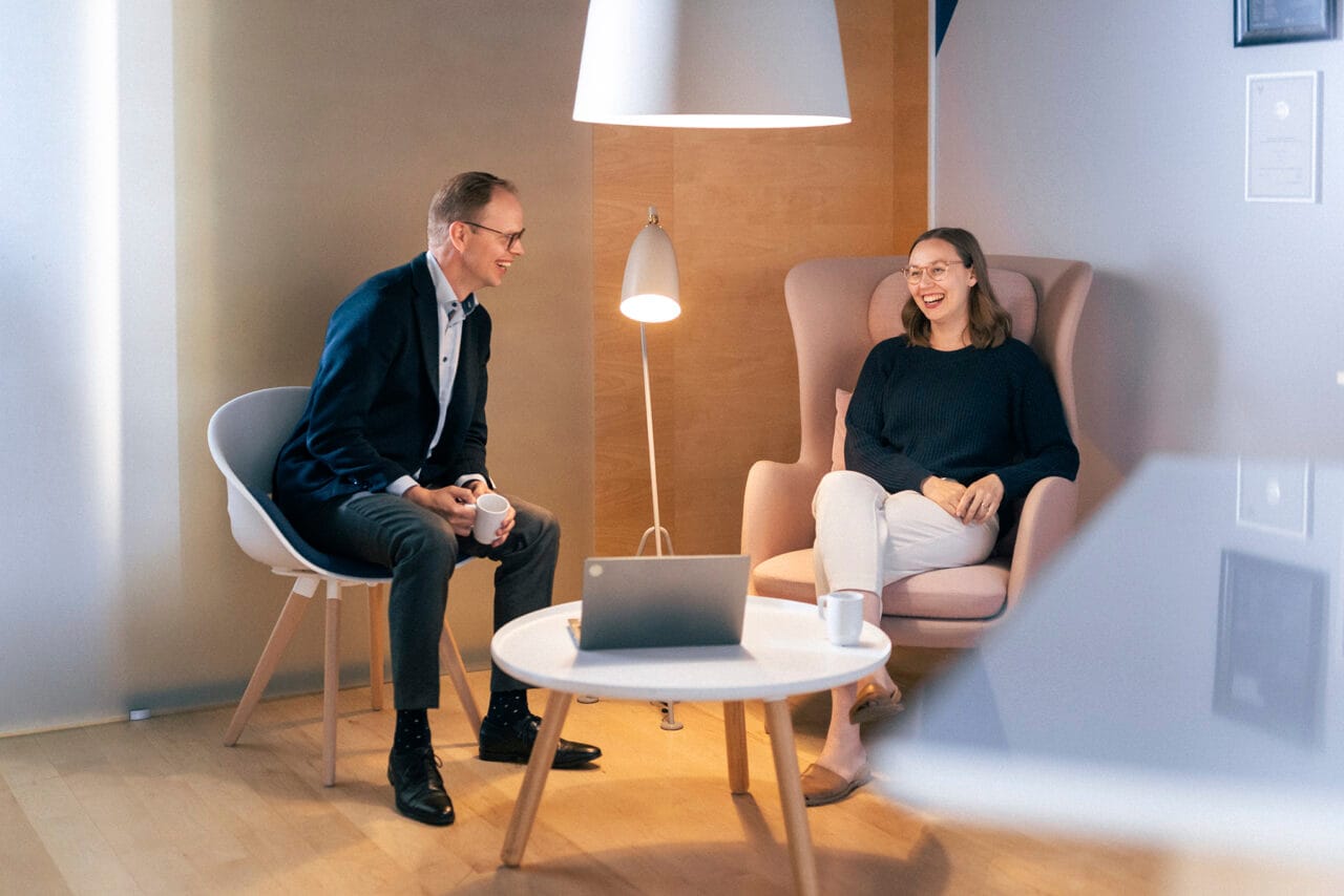 Mies ja nainen istuvat nojatuoleissa ja nauravat.
