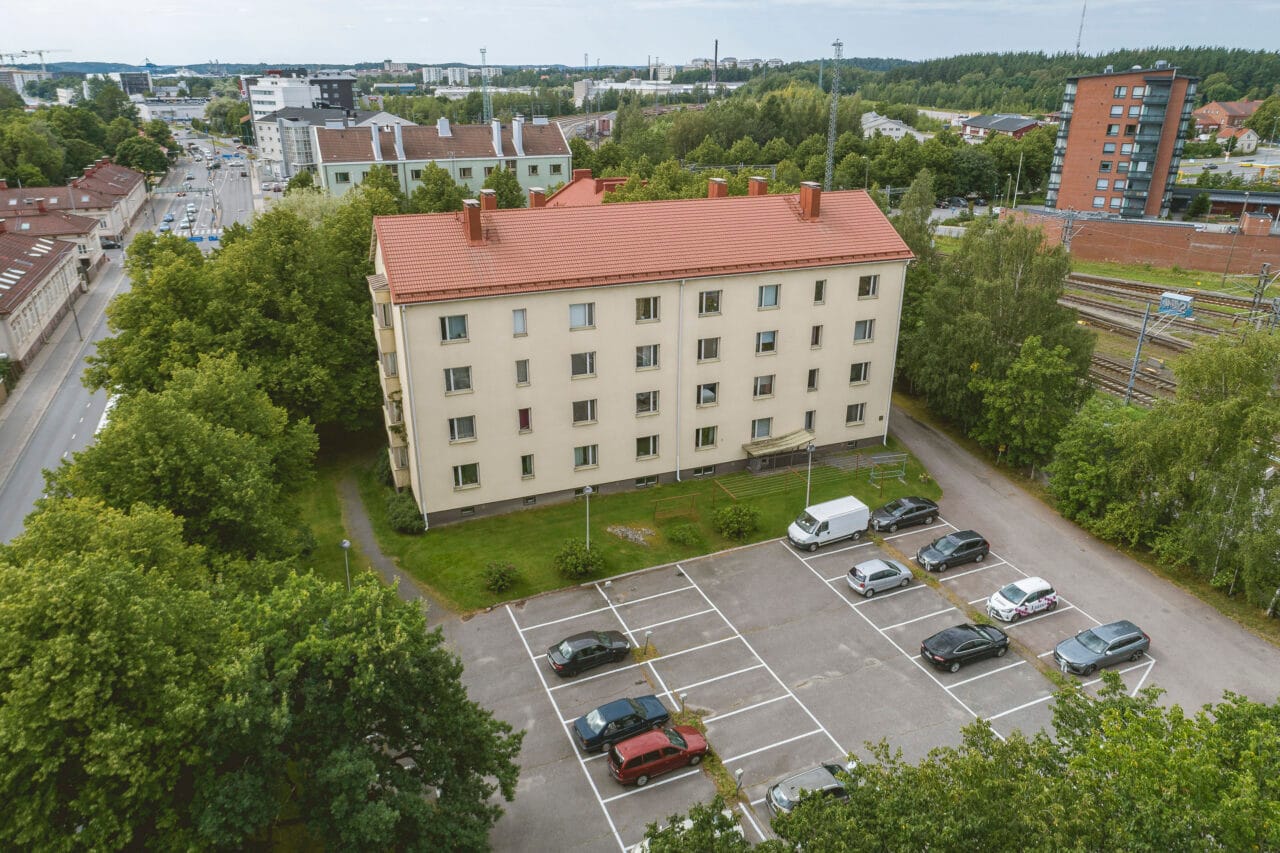 An aerial view of an apartment building and a parking area.